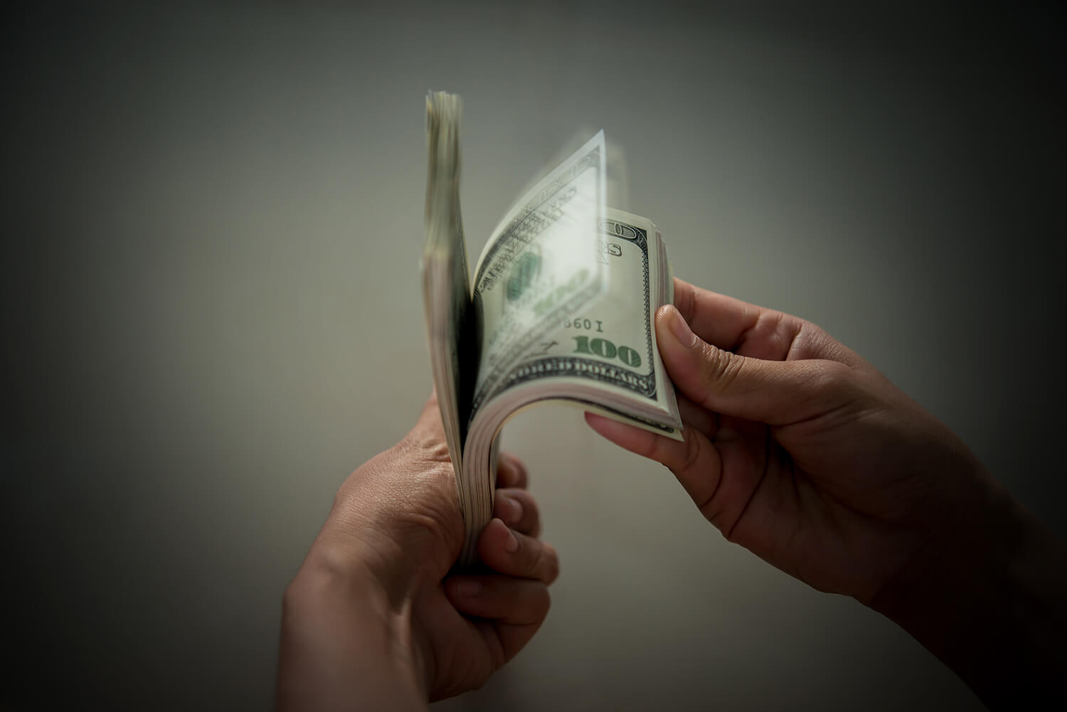 Mano sosteniendo billetes y monedas